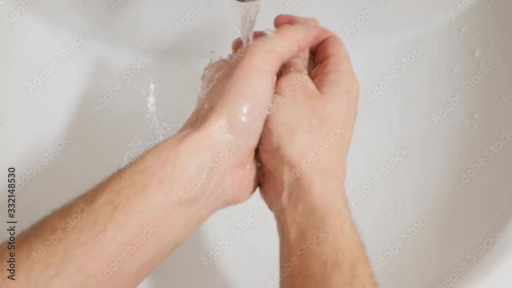 Man washes his hands with liquid soap in a bathroom. POV view, close-up slow-motion shot Man washes his hands with liquid soap in a bathroom. POV view, close-up slow-motion shot