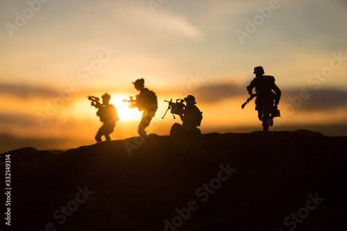 War Concept. Military silhouettes fighting scene on war fog sky background, World War Soldiers Silhouette Below Cloudy Skyline At sunset. © zef art