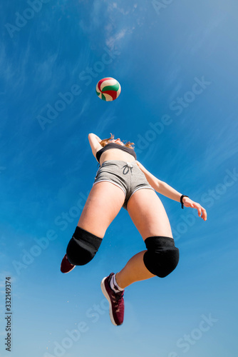 young athletic woman smashing  beach volley photo