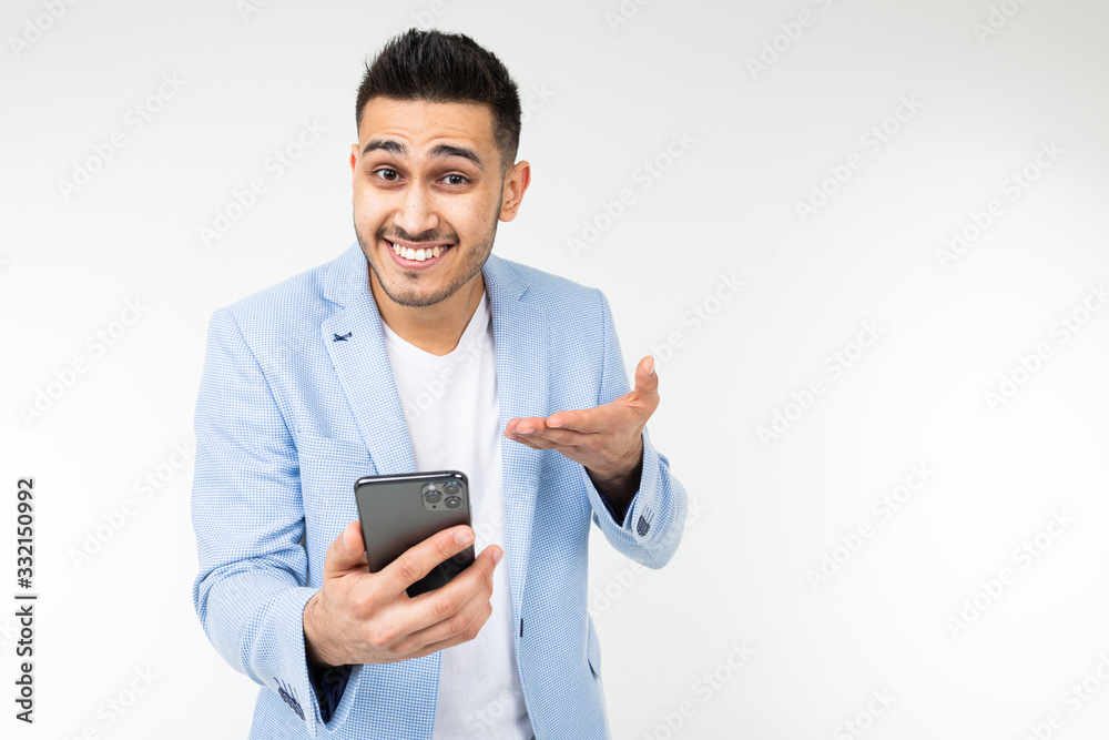 office brunette man in a jacket smilingly points to the screen of a gadget about a good offer of purchase on a white background office brunette man in a jacket smilingly points to the screen of a gadget about a good offer of purchase on a white background