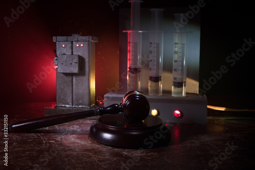 Prisoner handcuffed to death by lethal injection, vial with sodium thiopental and syringe on top of a table, conceptual image photo