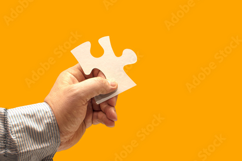 hand holding piece of jigsaw puzzle