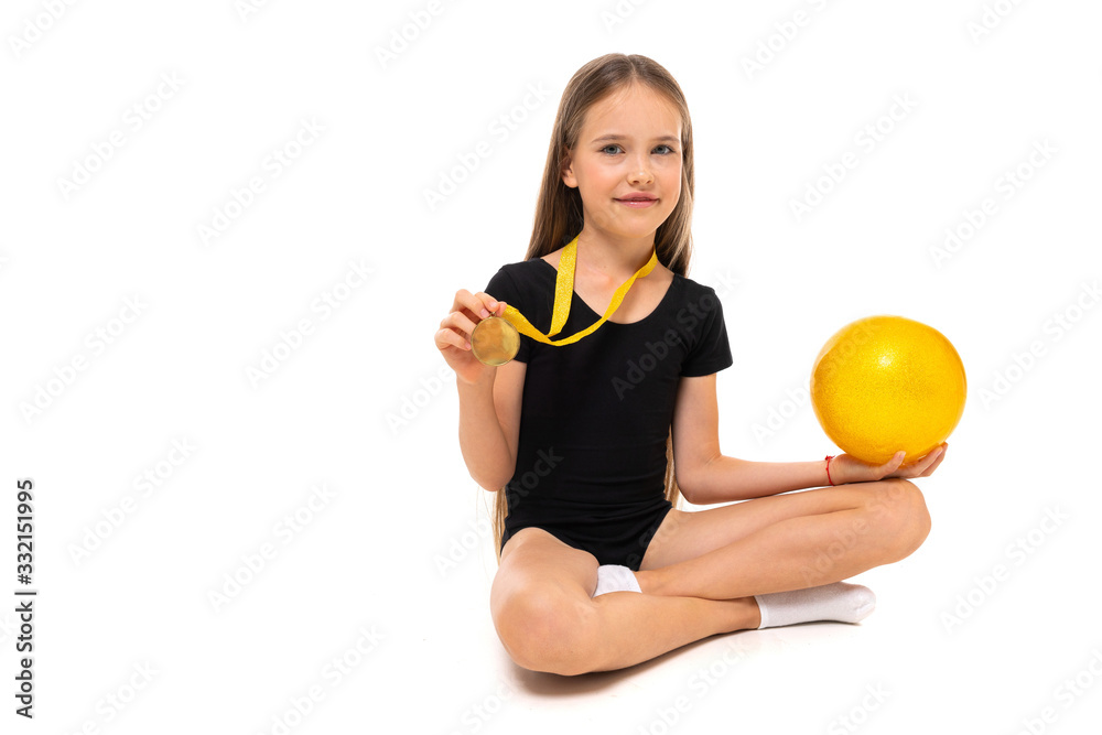 winner girl gymnast sitting on the floor with gymnastic ball on a white background with copy space winner girl gymnast sitting on the floor with gymnastic ball on a white background with copy space