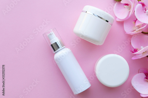 View from above on plastic jars with cream, pink background, space for text