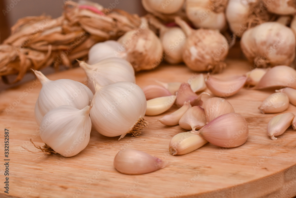 Garlic Cloves and Bulb on wooden cutting board. Garlic on wooden table background Garlic Cloves and Bulb on wooden cutting board. Garlic on wooden table background