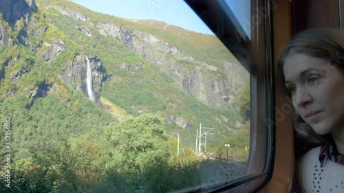 A Woman Taking in an Amazing View of Mountains and Waterfalls from on Board a Train in Norway, Slow Motion photo