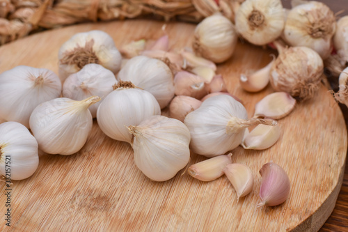 Garlic Cloves and Bulb on wooden cutting board. Garlic on wooden table background