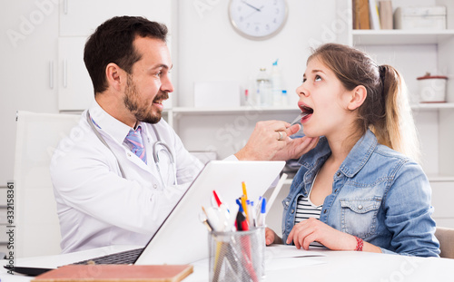 Doctor and girl with sore throat