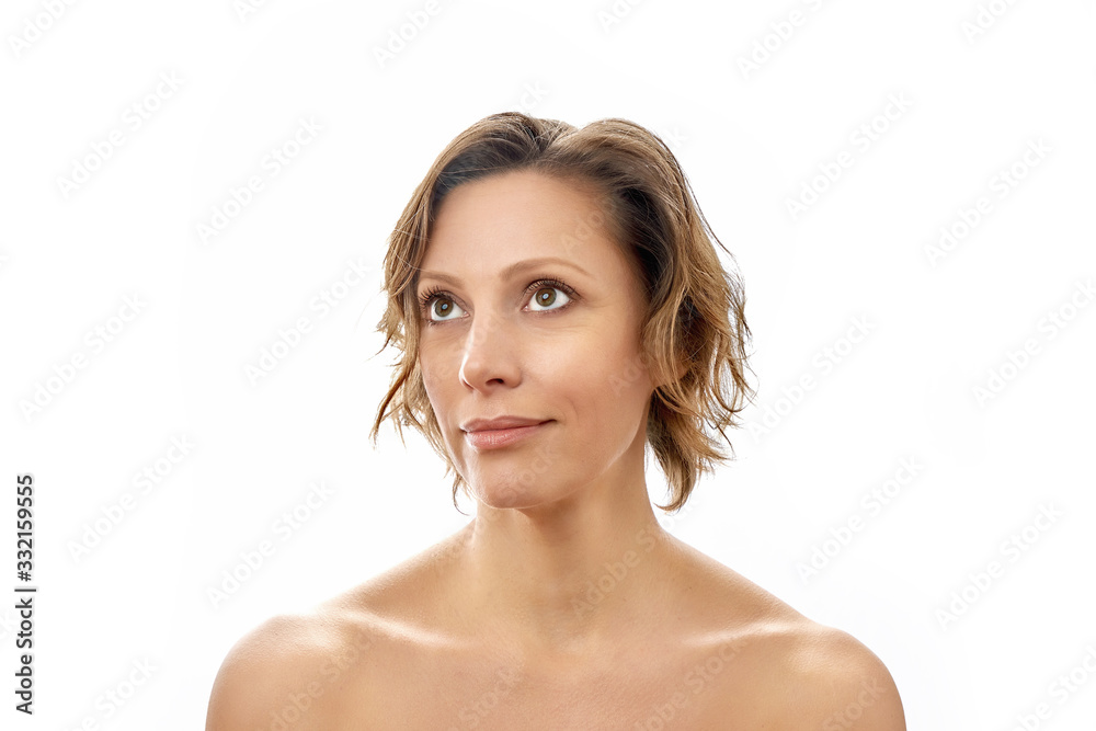 Beautiful young woman with a clean face naked to the shoulders posing. isolated white background. Beautiful young woman with a clean face naked to the shoulders posing. isolated white background.