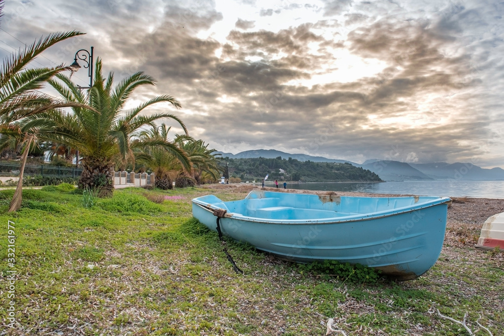 Obraz premium Sunset. Kids playing at the beach in Arkitsa under a dramatic cloudscape 