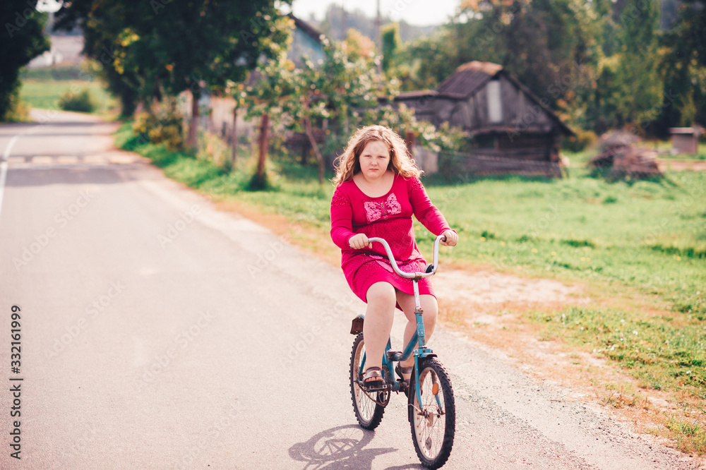 Handsome young caucasian girl rides a bike