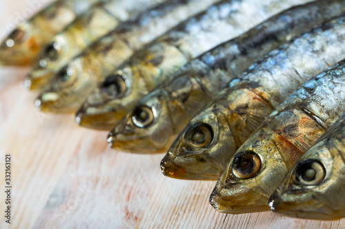 Salted and pressed sardines on wooden table © JackF