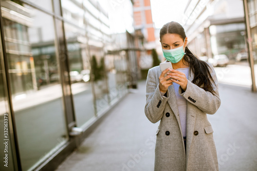 Pretty young woman with protective facial mask on the street
