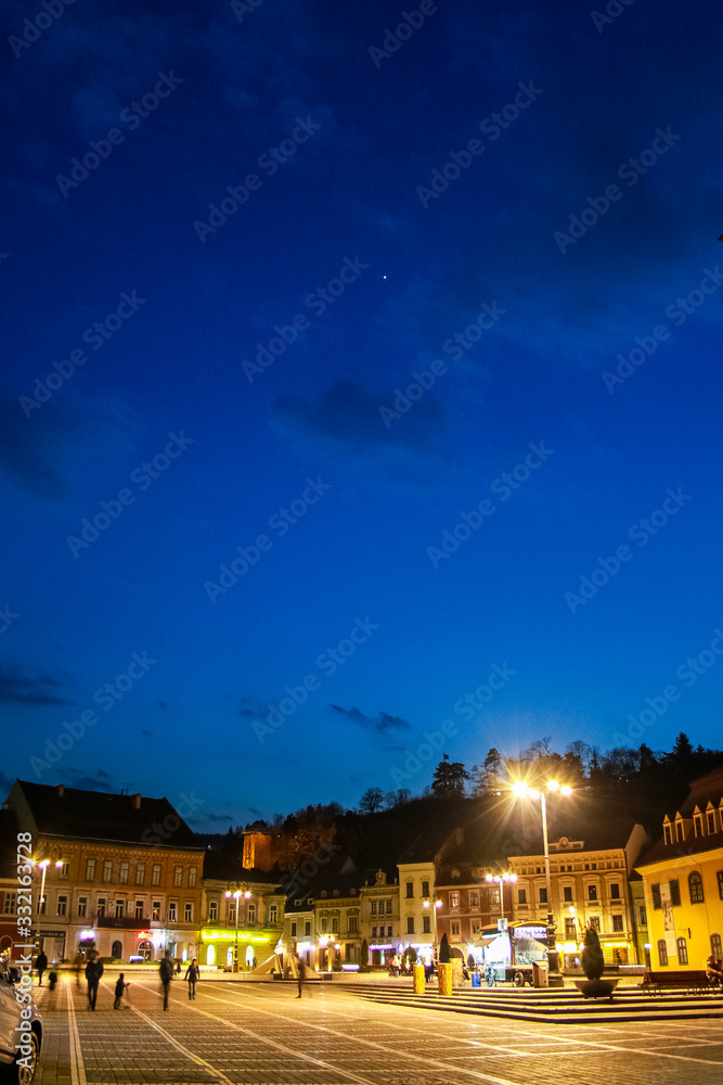 Naklejka premium Brasov's old city town square in the night, empty because of the coronavirus outbreak.