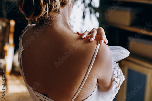 The bride with a bare back in a wedding dress