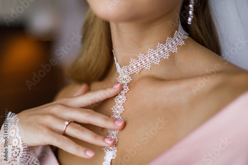 Girl in a dressing gown straightens jewelry on the neck