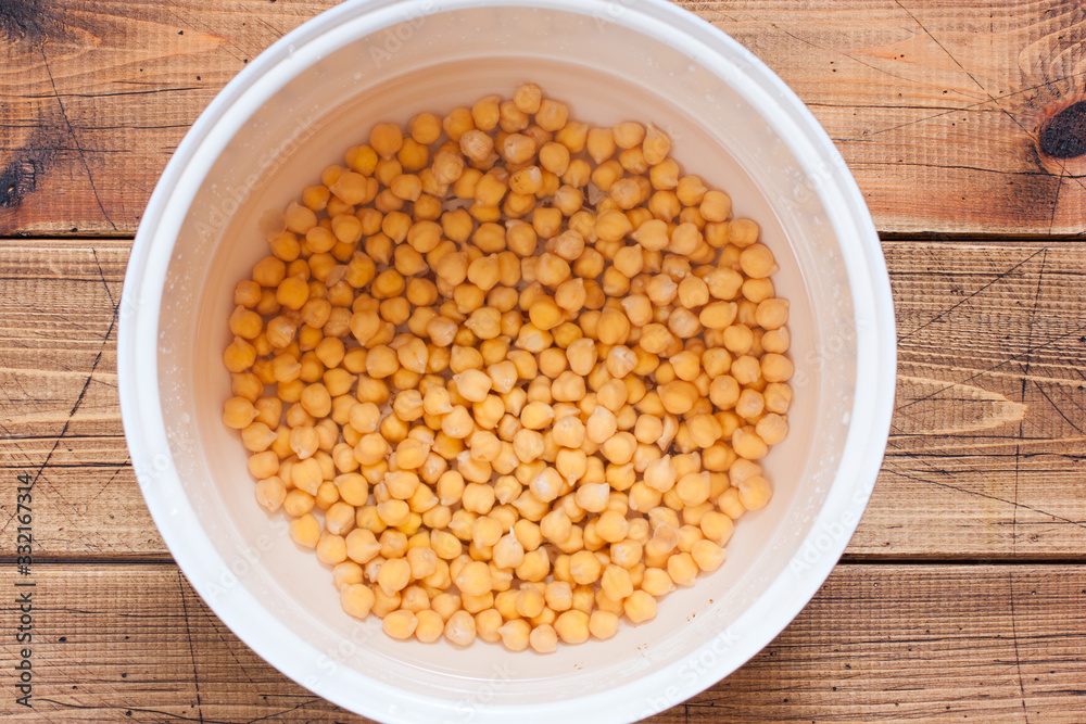 Raw chickpeas in a pan, drenched in water, before cooking, top view