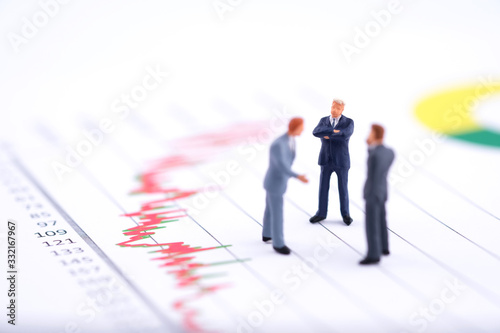 Miniature people:Businessman standing with team and discuss on the stock trend with copy space. Financial crisis. Data analysis. Stock market volatility risk. Information for investment.