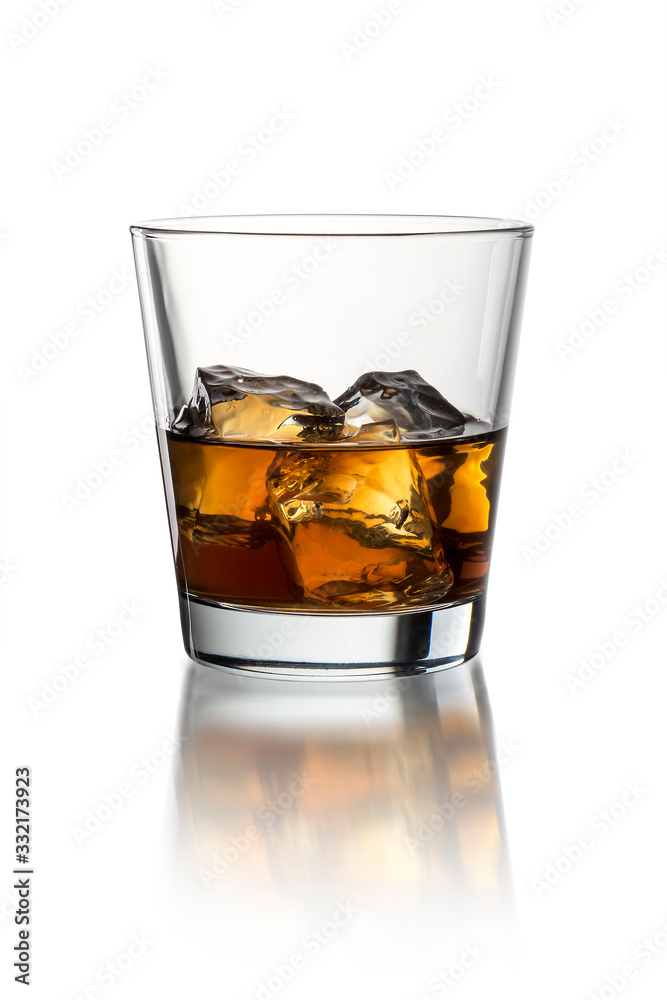 Glass with whiskey on the white background with ice Glass with whiskey on the white background with ice