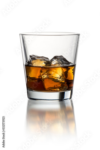 Glass with whiskey on the white background with ice