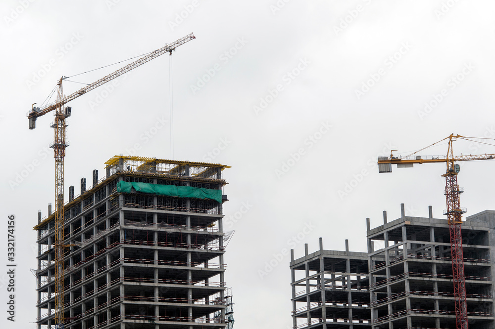 Construction of the frame of high-rise buildings against the overcast sky. Background Construction of the frame of high-rise buildings against the overcast sky. Background