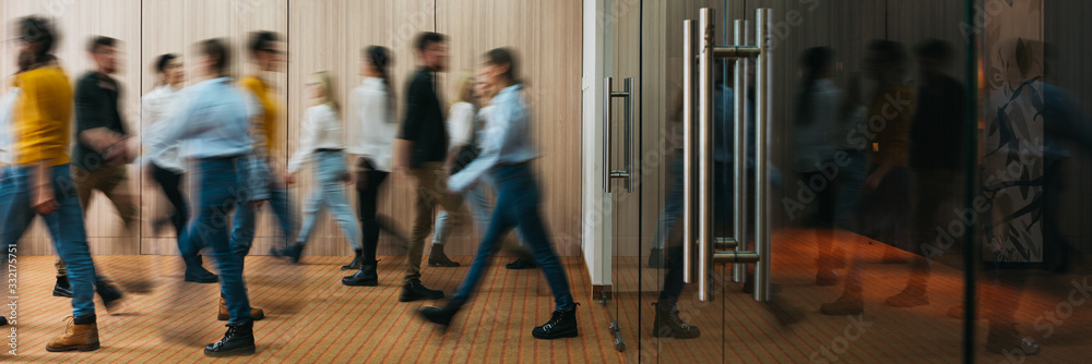 Group of business people walking at office openspace. Team of business employees at coworking center. People at motion blur. Concept working at action. Wide image - obrazy, fototapety, plakaty 