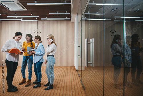 Group of young business people meeting at coworking office and discuss project. Team of employees standing at business space