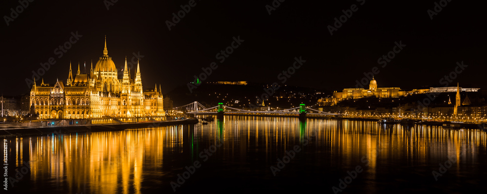 Panorama of Budapest with  Hungarian Parliament and Buda Castle.  Chain Bridge with green lights on St. Patrick's day in Budapest at night.