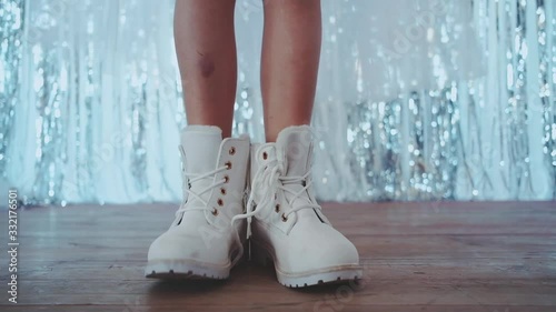 Portrait of slim girl in black pantyhose and pink boots dancing in studio. Indoor photo of graceful young lady in white lush skirt holding bottle of champagne.