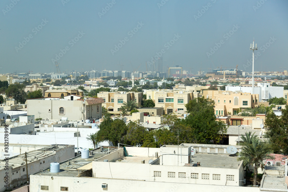 Old areas of the modern eastern metropolis. The small old houses and buildings of Dubai against the backdrop of new high-rise buildings.