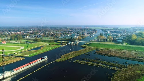 Two Big Cargo Boats Approaching a Bridge, Tracking Shot - Friesland, The Netherlands / Holland 4K Drone Footage photo