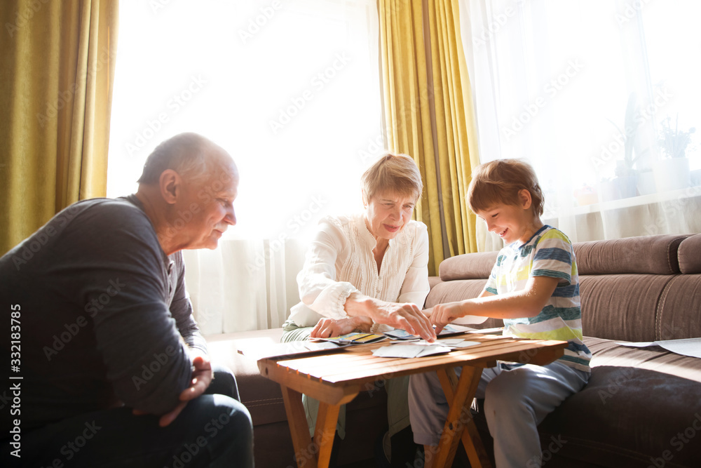 Grandparents playing board game with grandson - obrazy, fototapety, plakaty 