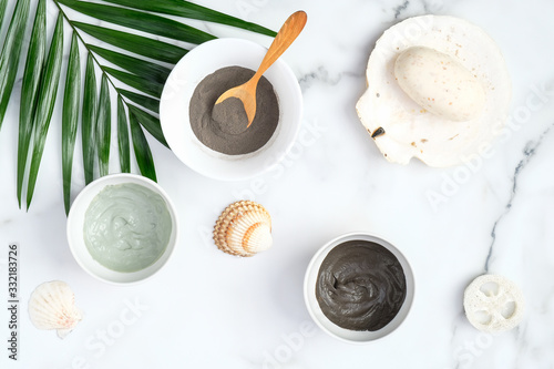 Cosmetic clays in bowls on marble background. Natural organic cosmetic face mask. Facial skin care, beauty treatment. Flat lay, top view