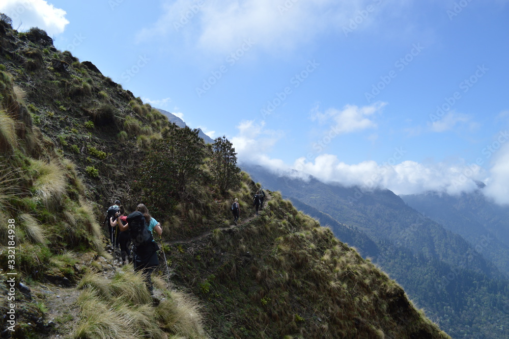 Wandergruppe in den Bergen, am Hang im Himalaya auf schmalem Pfad