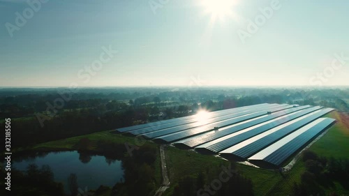 Solar Plant: Rows of Solar Panels Producing Sustainable Energy, Dark with Reflection From the Sun, Moving Right - Friesland, Netherlands / Holland – 4K Drone Footage photo