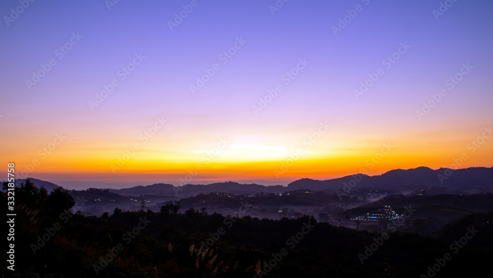 golden light before sunrise on foggy mountain landscape