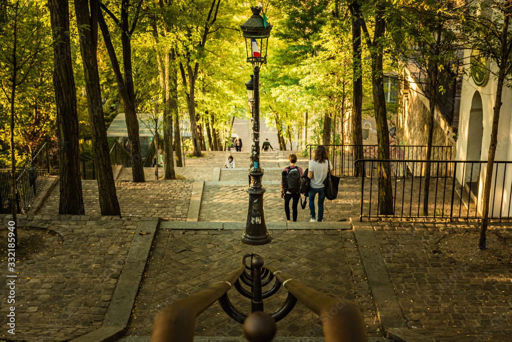 Students walk down the Montmartre steps in the early morning sunlight, Paris, France