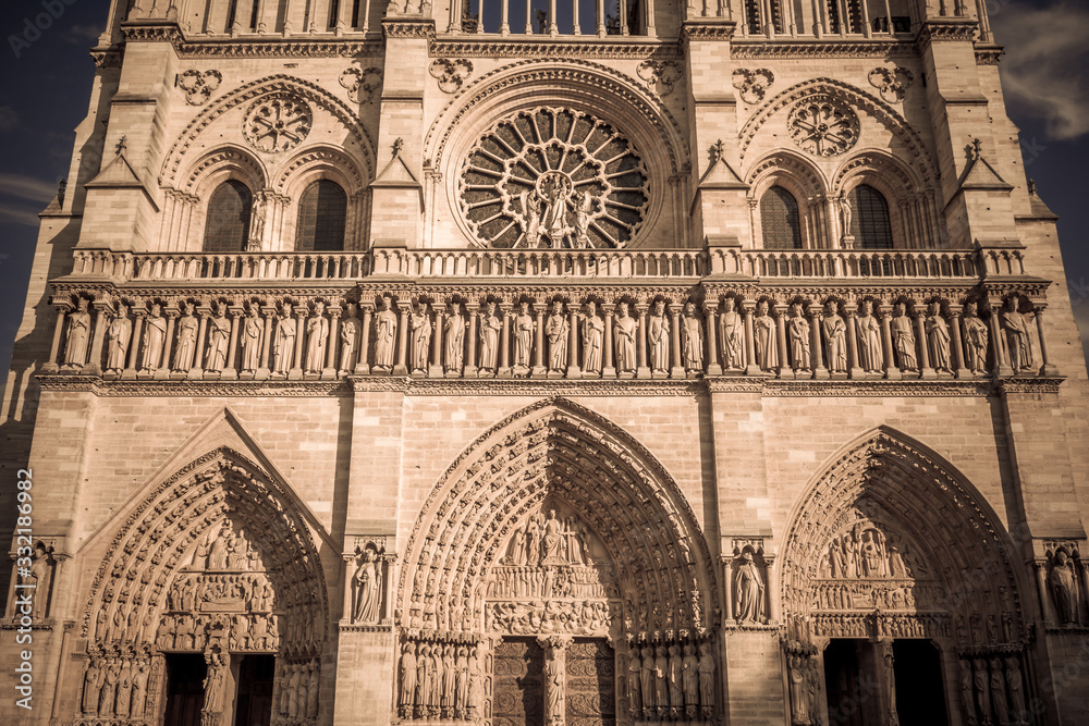 Detail of the Notre Dame Cathedral facade stone work and rose window on a sunny autumn afternoon