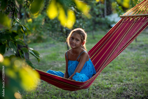 little girl on a swing. young woman reading a book in the park. young girl in hammock