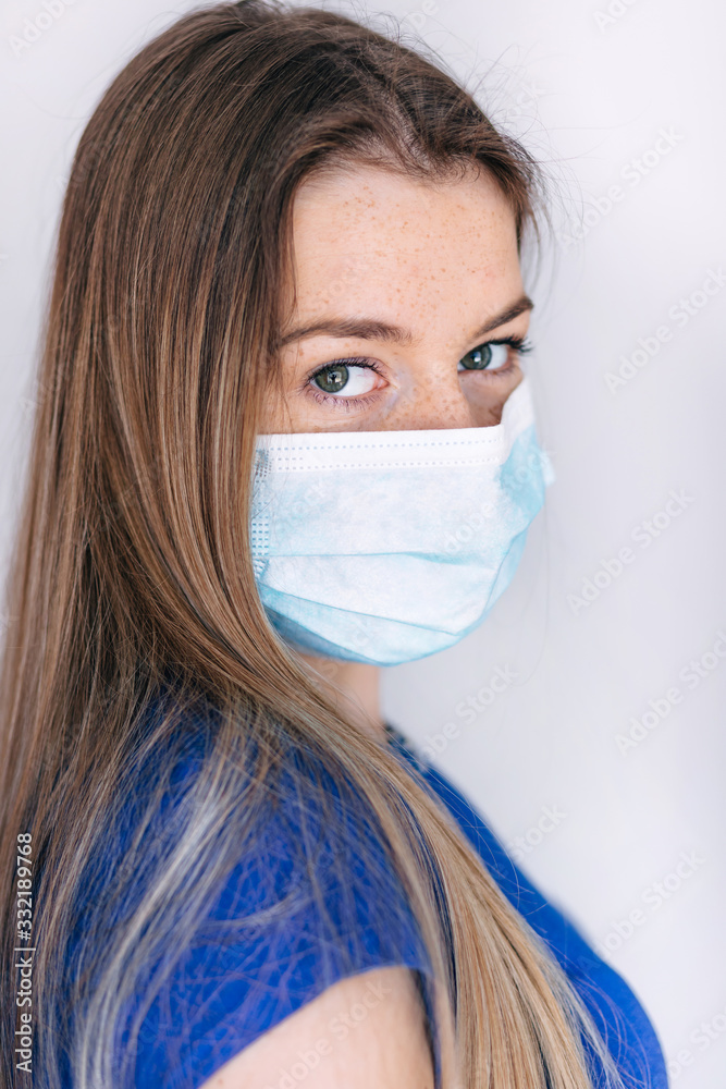 Beautiful but sad woman with medical mask on face on a white background. The woman is sad because she is afraid of modern viruses that bring diseases. The medical mask warns against viruses Beautiful but sad woman with medical mask on face on a white background. The woman is sad because she is afraid of modern viruses that bring diseases. The medical mask warns against viruses