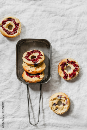 Group of cottage cheese donuts with blueberries and jam in a vintage iron pan on modern white linen