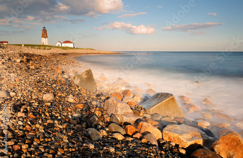 Point Judith Lighthouse at sunset at Narragansett, RI, USA. The lighthouse  is located on the west side of the entrance to Narragansett Bay. Slow motion of water was applied. photo