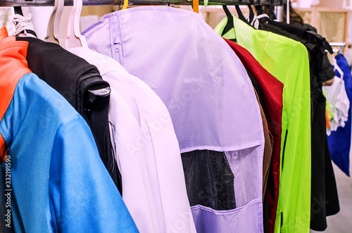 A row of stage costumes for upcoming performances by dance actors hangs on a floor hanger, toned. photo