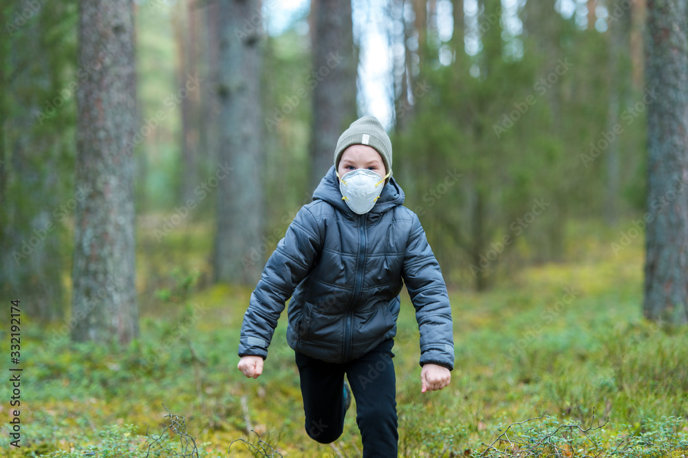 Little boy with a mask run in the forest. Corona virus quarantine Little boy with a mask run in the forest. Corona virus quarantine