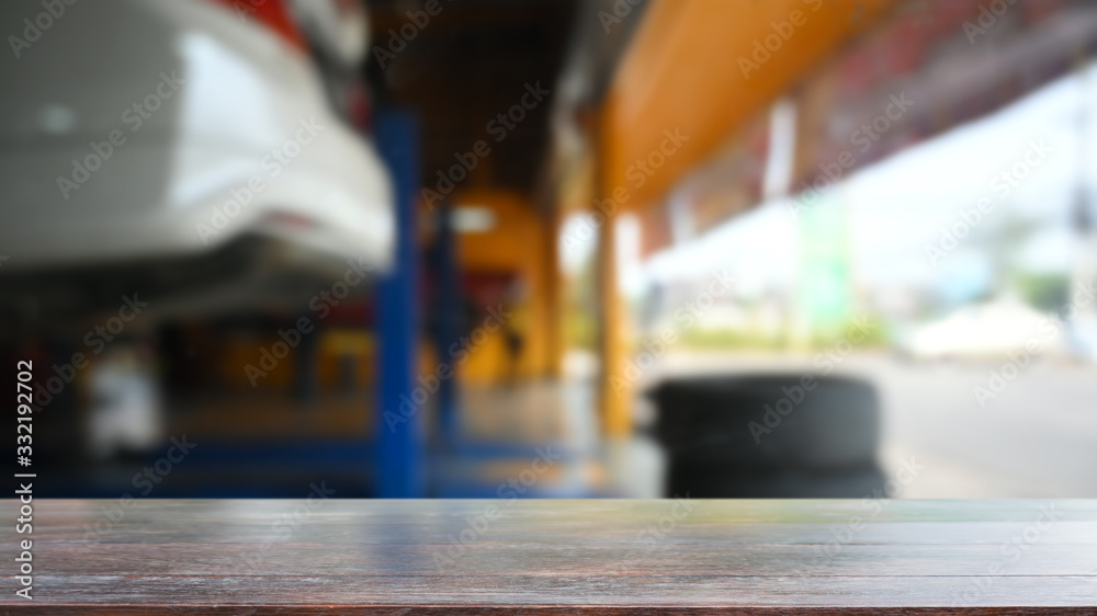 Empty wood table top on blur factory garage background. Montage wooden table with blurred garage background. Empty wood desk for present product.