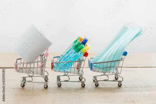 Tissue or toilet paper hand sanitizer or alcohol gel and sergical face mask on each shopping cart seems like shopping in supermarket. Concept of hoard nescessary supply for protect Covid-19 photo