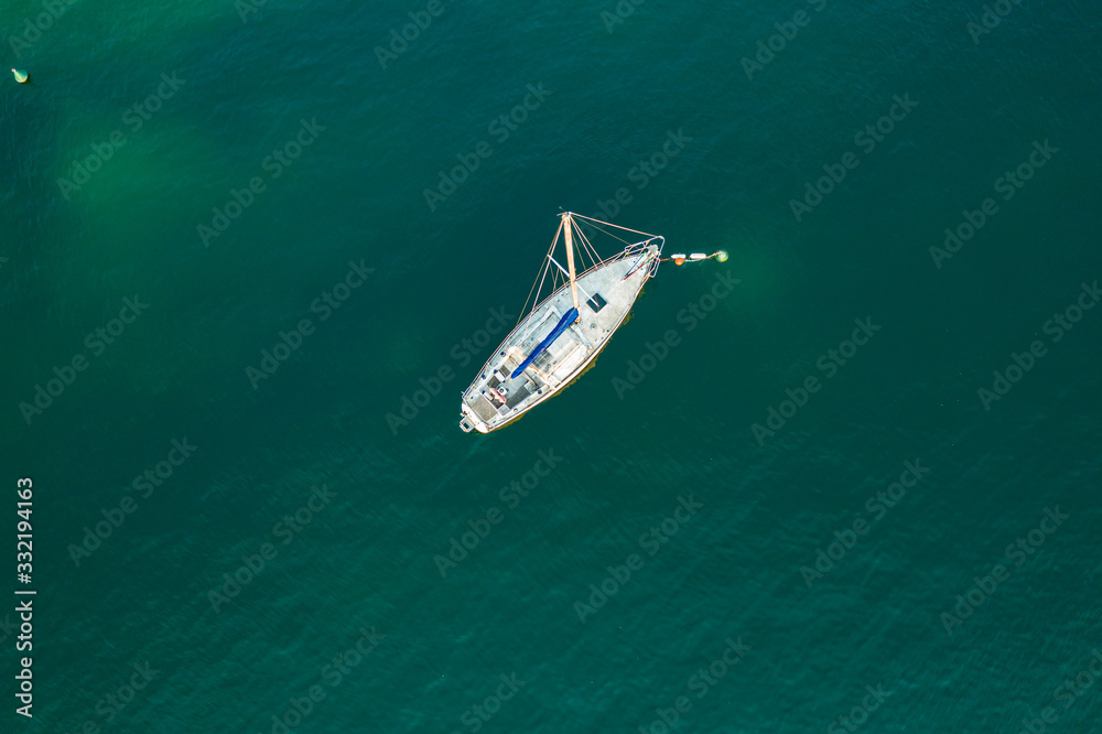 Aerial view of sailboat anchored in Lago di Garda, Italy Aerial view of sailboat anchored in Lago di Garda, Italy