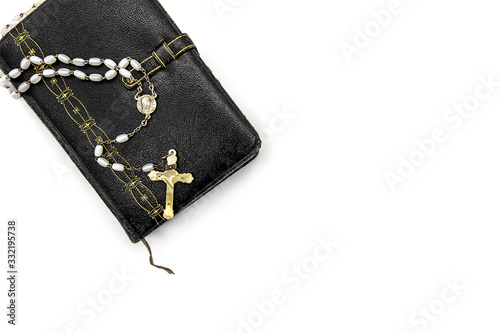 Old, prayer book with rosary on a white background