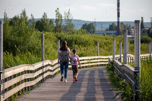 Obraz na płótnie mom and daughter walking on a bridge w salonie