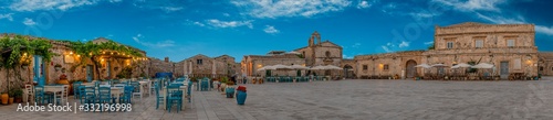 Panoramic view of the picturesque sicilian village Marzamemi, view of the traditional outdoor cafe and the church and the central square, province of Syracuse, Sicily, southern Italy